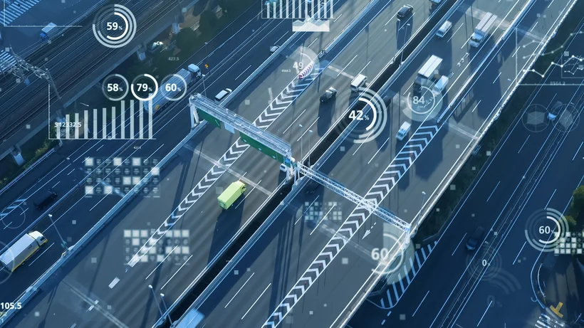 Luftaufnahme einer Autobahn mit Fahrzeugen und digital eingeblendeten Daten, die intelligente Verkehrssysteme symbolisieren.