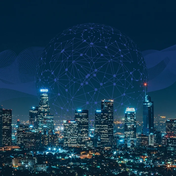 Skyline einer Stadt bei Nacht mit einem Netzwerk aus blauen verknüpften Punkten in Sphärenform darüber.