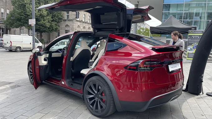 Rotes Auto mit geöffneten Flügeltüren