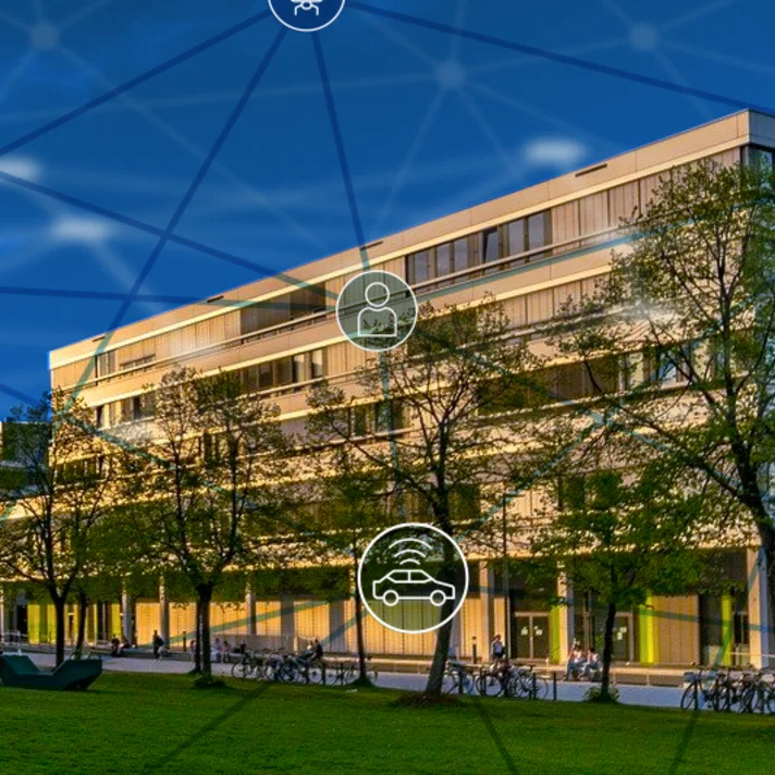 Modernes, mehrstöckiges Gebäude bei Sonnenuntergang, umgeben von Bäumen und Fahrrädern. Im Vordergrund ist eine Rasenfläche. Über das Bild sind transparente, vernetzte Symbole aus dem Bereich Mobilität (z. B. Auto, Bus, Bahn) gelegt, die eine digitale Vernetzung oder Smart-City-Technologie symbolisieren.