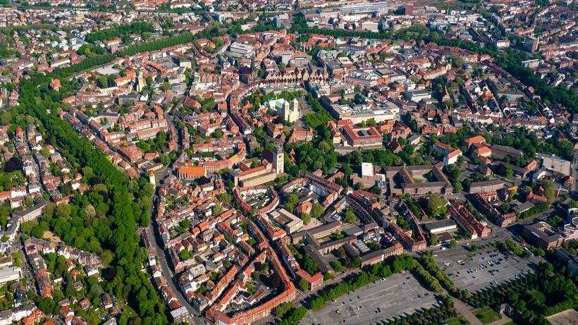 uftaufnahme der Stadt Münster in Nordrhein-Westfalen mit dem Dom im Zentrum, umgeben von historischen Gebäuden, Straßenringen und Grünflächen.