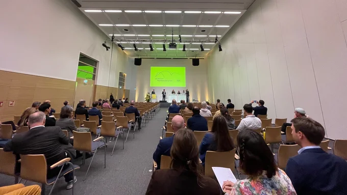 Konferenzraum mit Publikum und Podium, auf dem mehrere Personen bei einem Mobilitätskongress sprechen.