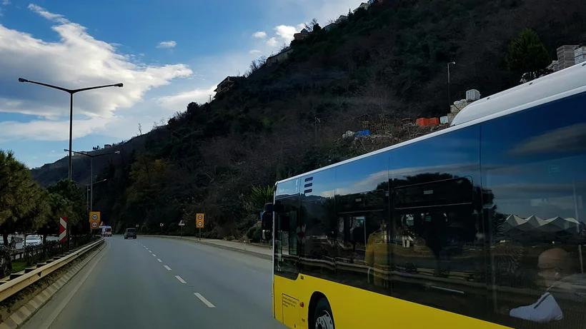 Ein gelber Bus fährt auf einer Landstraße