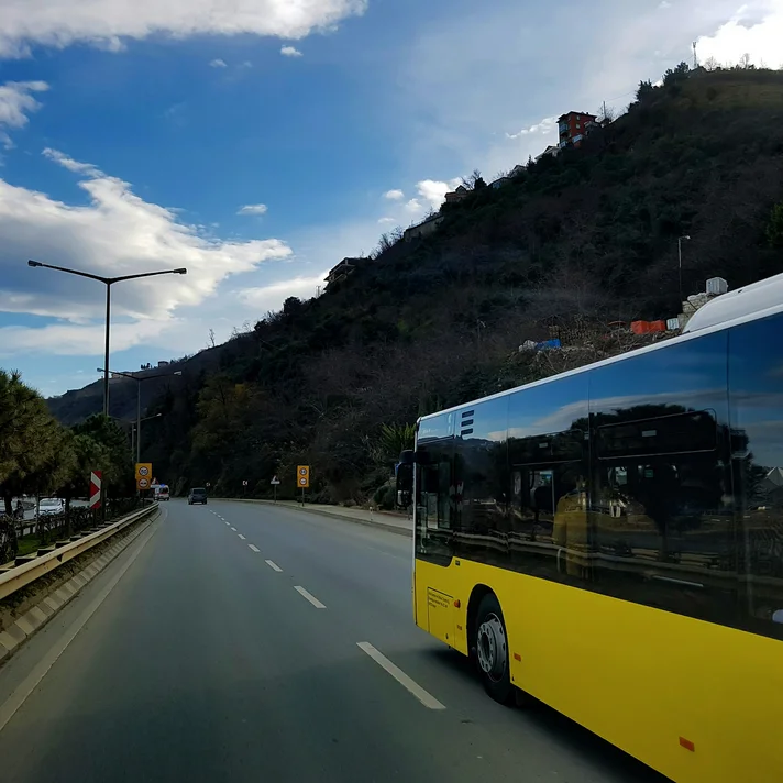 Ein gelber Bus fährt auf einer Landstraße
