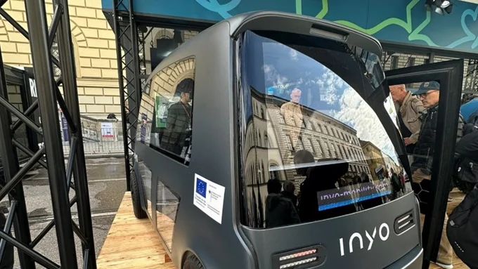 Ein automatisiertes Shuttle von vorne fotografiert, dasLaber des Herstellers INYO ist auf dem antharzitfarbenen Rahmen zu sehen.