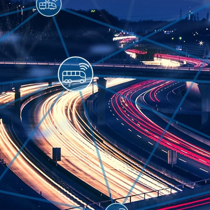 Nachtaufnahme eines Autobahnkreuzes mit Lichtspuren fahrender Fahrzeuge, überlagert von blauen Linien und Symbolen für vernetzte Mobilität wie Auto, Bus, Fahrrad und Nutzer.        ChatGPT fragen
