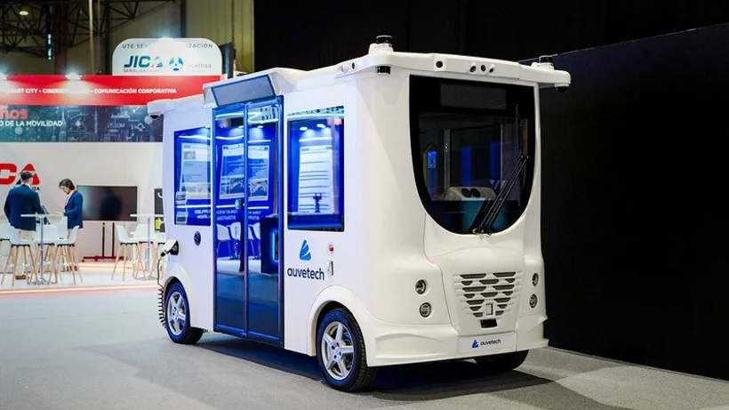 Kleiner weißer autonomer Bus-Schuttle steht in der Messehalle