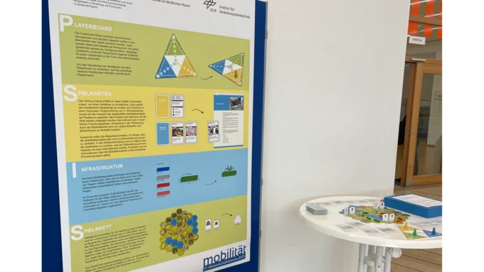 An einer blauen Posterwand hängt ein Plakat mit den Spielregeln zum Spiel "Landpartie". Daneben ist ein weißer Stehtisch mit dem aufgebauten Spiel.