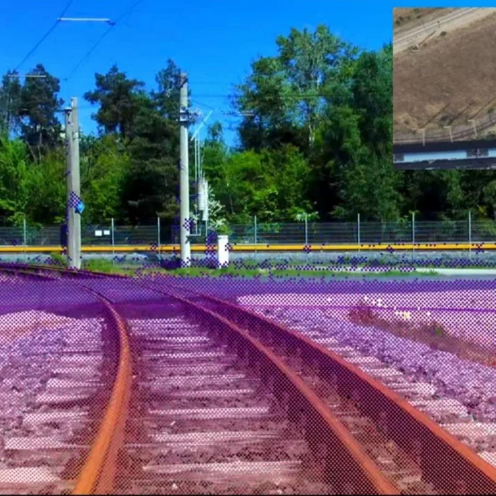 Blick auf zwei sich verzweigenden Bahngleise vor bewaldeter Kulisse mit einem kleinen Kartenausschnitt oben rechts.