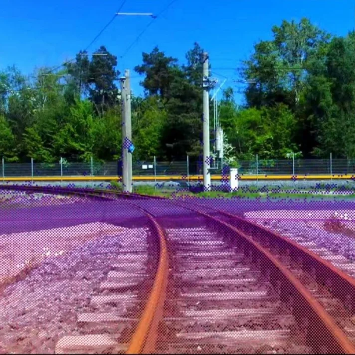 Blick auf zwei sich verzweigenden Bahngleise vor bewaldeter Kulisse mit einem kleinen Kartenausschnitt oben rechts.