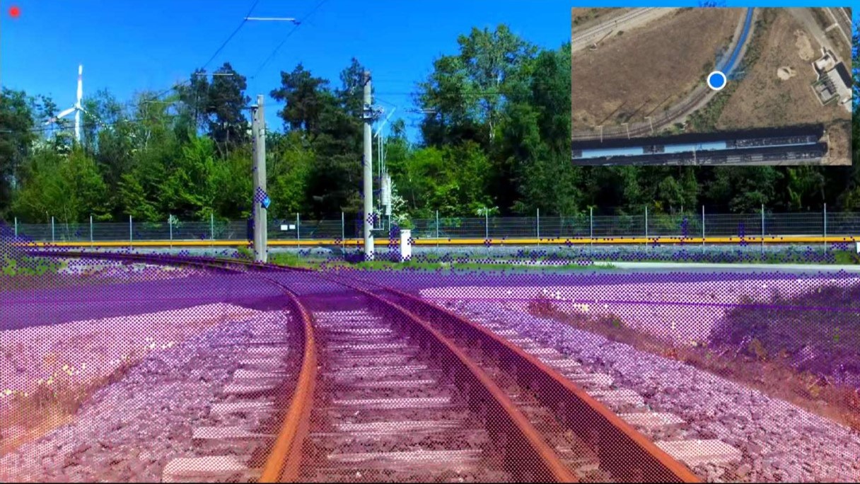 Blick auf zwei sich verzweigenden Bahngleise vor bewaldeter Kulisse mit einem kleinen Kartenausschnitt oben rechts.